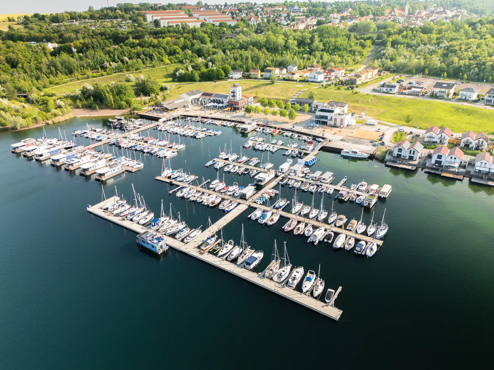 Luftaufnahme der Marina Mücheln am Geiseltalsee mit Bootsstegen, Hafengebäuden und Ferienhäusern am Ufer